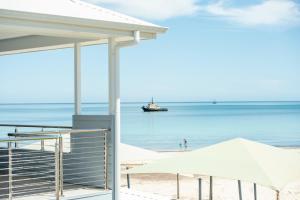 a view of the beach with a boat in the water at Wallaroo Beachfront Tourist Park in Wallaroo