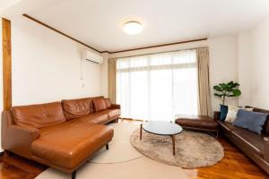 sala de estar con sofá de cuero y mesa en Mizunowa B035, en Nago
