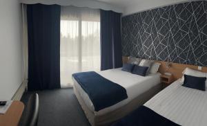 Tempat tidur dalam kamar di The Originals City, Hôtel Villancourt, Grenoble Sud (Inter-Hotel)