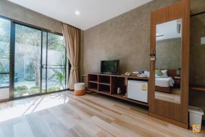 a bedroom with a bed and a large window at Blue River Resort in Phitsanulok