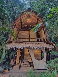 una grande capanna con tavolo e sedie di KRABI BAMBOO KINGDOM at AOLUEK PARADISE ad Ao Luk