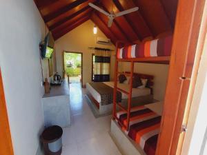 Zimmer mit 2 Etagenbetten und einem TV in der Unterkunft Inn On The Bay in Pasikuda