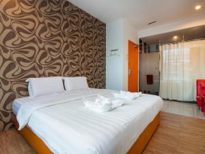 a bedroom with a large bed with white towels on it at 1 Hotel Taman Connaught in Kuala Lumpur