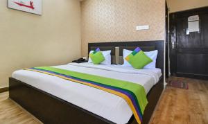 ein Schlafzimmer mit einem großen Bett mit bunten Kissen in der Unterkunft Treebo Siddharth in Ajmer + 30 Fotos