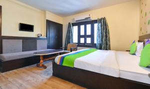 ein Schlafzimmer mit einem Bett und einem Schreibtisch in einem Zimmer in der Unterkunft Treebo Siddharth in Ajmer