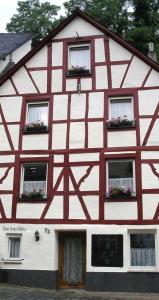 ein rotweißes Gebäude mit Fenstern und Blumen in der Unterkunft Ferienhaus Anna Maria in Bernkastel-Kues