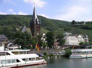 two boats are docked in a river with a church at Ferienhaus Anna Maria in Bernkastel-Kues