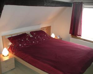 a bedroom with a large red bed with two lamps at Ferienhaus Anna Maria in Bernkastel-Kues