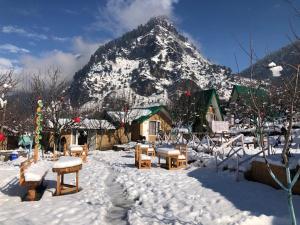 uma montanha coberta de neve em frente a um alojamento de turismo selvagem em Enthralling Escapes Nature Stay and Trek em Manali
