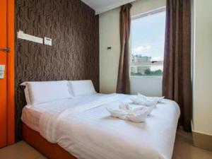 a bedroom with a white bed with a window at 1 Hotel Taman Connaught in Kuala Lumpur