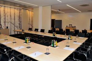 a conference room with rows of tables and chairs at Centrale Hotel und Restaurant in Waldkraiburg