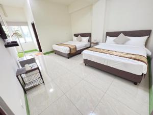 a bedroom with two beds and a balcony at Mu Travel B&B in Kenting