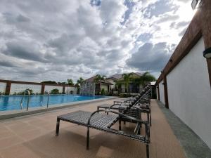 una fila de bancos sentados en un balcón con piscina en Heidi Sanctuary Resort by Cocotel en Ángeles