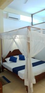 una camera da letto con un letto a baldacchino di Ocean Gate Villa Tangalle a Tangalle