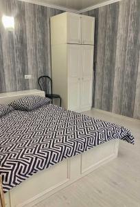 a bedroom with a bed with a black and white comforter at Apartment квартира Ярослава Мудрого in Kryvyi Rih