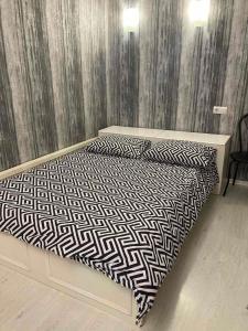 1 cama con edredón y almohadas en blanco y negro en Apartment квартира Ярослава Мудрого, en Krivoy Rog