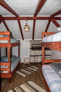 a bedroom with two bunk beds and a chandelier at Cabana „Stâna din Deal” in Proviţa de Sus