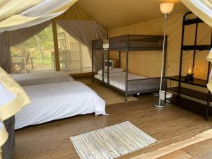 a bedroom with two bunk beds in a tent at Canopy Villa Tampik Valley in Kampong Sum Sum