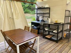 a patio with a table and a table and a kitchen at Canopy Villa Tampik Valley in Kampong Sum Sum