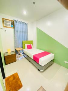 a small bedroom with a bed and a table at Happy Homes Manila in Manila