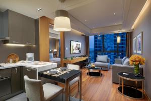 a kitchen and living room with a couch and a table at Ascott Raffles City Beijing in Beijing +31 photos