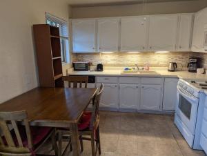 a kitchen with white cabinets and a wooden table at Warm and Welcoming 2BR close to UNM North Campus in Albuquerque