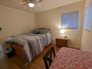 a bedroom with a bed and a table and a window at Warm and Welcoming 2BR close to UNM North Campus in Albuquerque