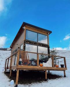 a tiny house sitting on a bench in the snow at Roua by NorAtlas Heritage - Adults Only in Varlămul +7 photos