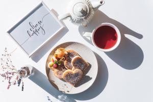 a table with a plate of cake and a cup of tea at la belle vue Boutique Hotel & Café in Spiez +107 photos
