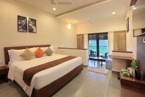 a hotel room with a bed and a balcony at Tea Terrain Resorts & Spa in Vagamon