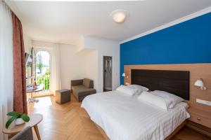 ユーバーリンゲンにあるHotel Ochsenの青い壁のベッドルーム1室(大型ベッド1台付)