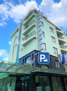 un edificio alto con una señal de estacionamiento delante de él en Light Hotel, en Sofía