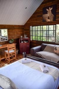 a bedroom with a bed and a couch in a room at Khululeka Guest Farm in Millvale
