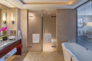 a bathroom with a tub and a shower and a sink at Regent Beijing in Beijing