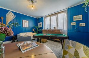 a living room with a pool table and blue walls at Joli Studio coté jardin in Bidache