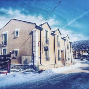 a building with snow on the ground in front of it at Vila Boem in Gura Humorului