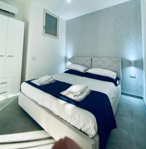 una camera da letto con un grande letto con lenzuola blu e bianche di Palinuro blue holiday home a Palinuro