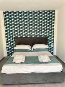 1 cama grande con cabecero azul y blanco en Palinuro blue holiday home, en Palinuro