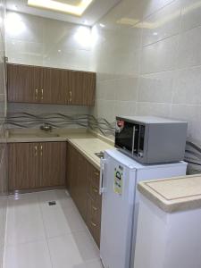 a kitchen with a white refrigerator and a microwave at Elite Furnished Units in Riyadh