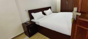 a bedroom with a large bed with white sheets and pillows at Nature Heights BNB in Nainital