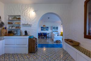 una cocina con un arco que conduce a una sala de estar en su mari su entu Isola di Sant'Antioco villa con accesso diretto al mare en SantʼAntioco Ponti