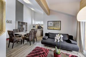 a living room with a couch and a table at LoriVita Residenz Saalbach in Saalbach-Hinterglemm