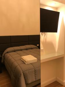 1 dormitorio con cama y mesa blanca en Motta Palace Apartments & Rooms, en Motta SantʼAnastasia