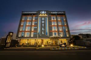 un bâtiment d'hôtel avec une horloge en haut dans l'établissement Garden Millennium Hotel, à Jazan