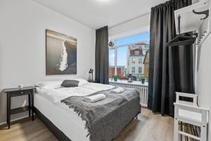 a bedroom with a bed and a large window at Odinn Reykjavik Skolavordustigur Apartments in Reykjavík