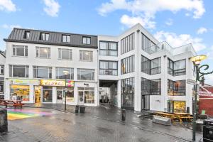 a large white building with a rainbow in front of it at Odinn Reykjavik Skolavordustigur Apartments in Reykjavík