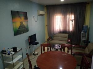 a living room with a table and a couch at XrisBun Apt 1BR - Laderin GRA in Abeokuta