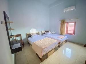 Ein Bett oder Betten in einem Zimmer der Unterkunft Homestay Tirtasari Pinrang City Center Mitra RedDoorz