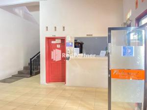 eine rote Tür in der Mitte eines Zimmers mit einer Theke in der Unterkunft Homestay Tirtasari Pinrang City Center Mitra RedDoorz in Pinrang