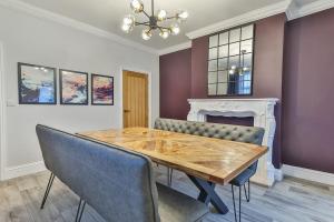 a dining room with a wooden table and a fireplace at Luxury Spacious Pad with Games Room in Sheffield